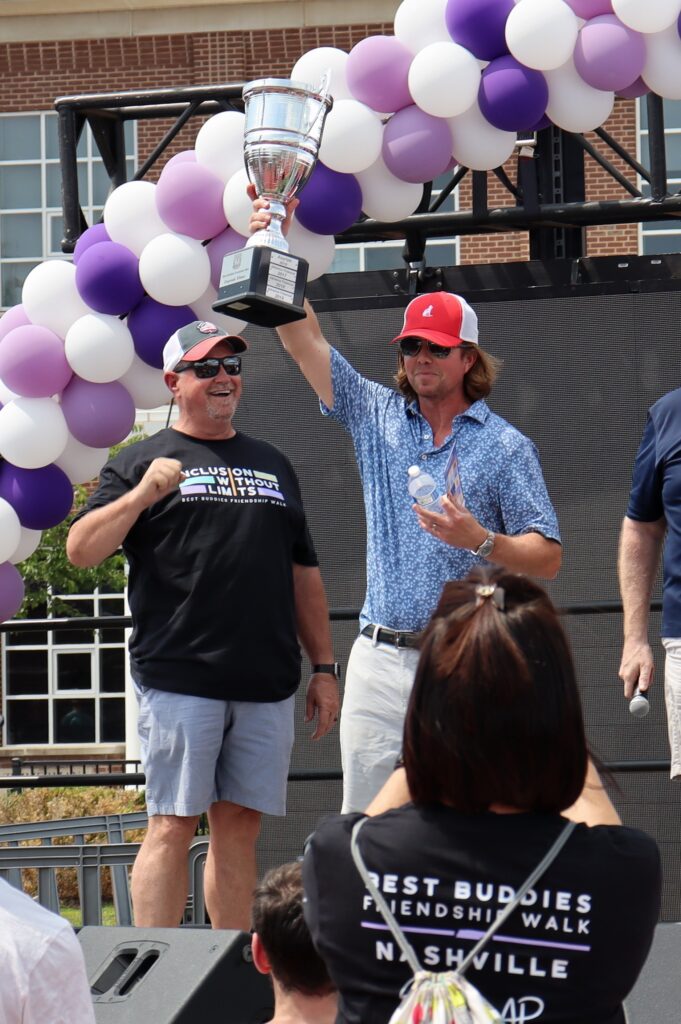 DNI leader hoisting trophy at Best Buddies Friendship Walk 2023
